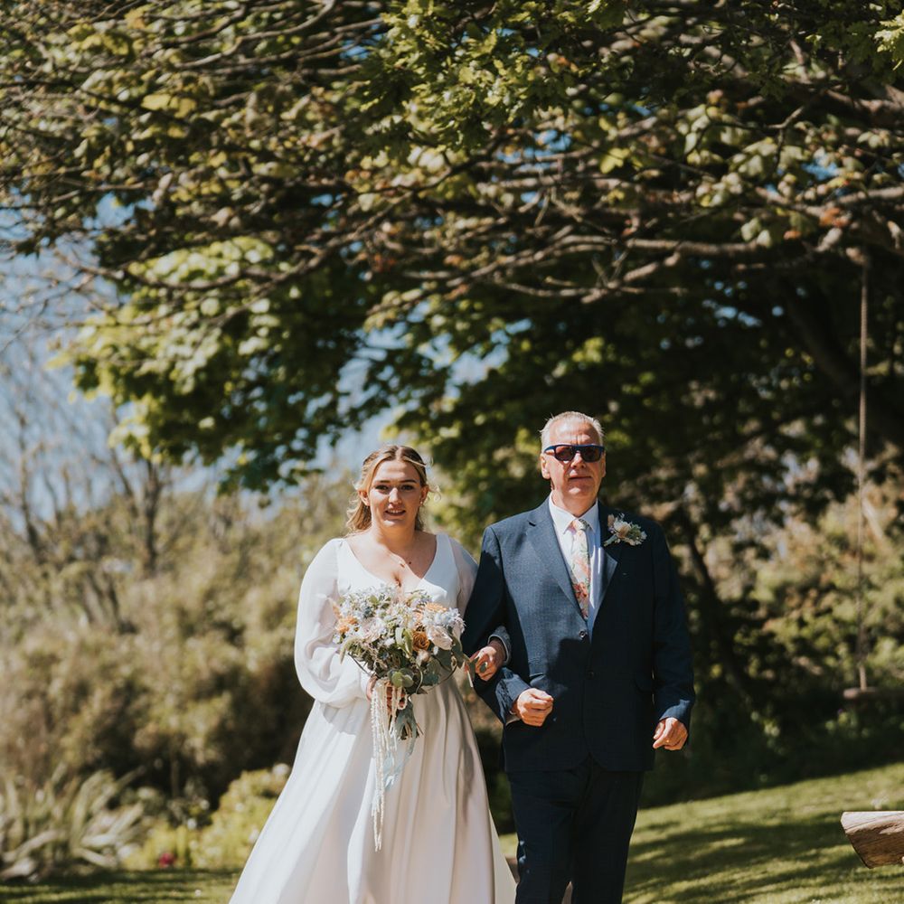 bride-walks-down-the-aisle-with-father-of-the-bride