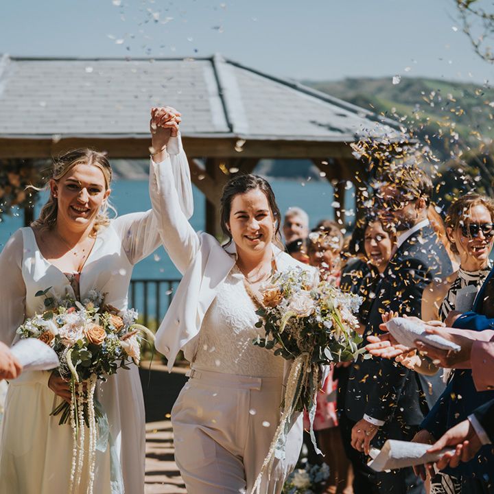 couple-holds-hand-in-the-air-in-celebration-with-confetti
