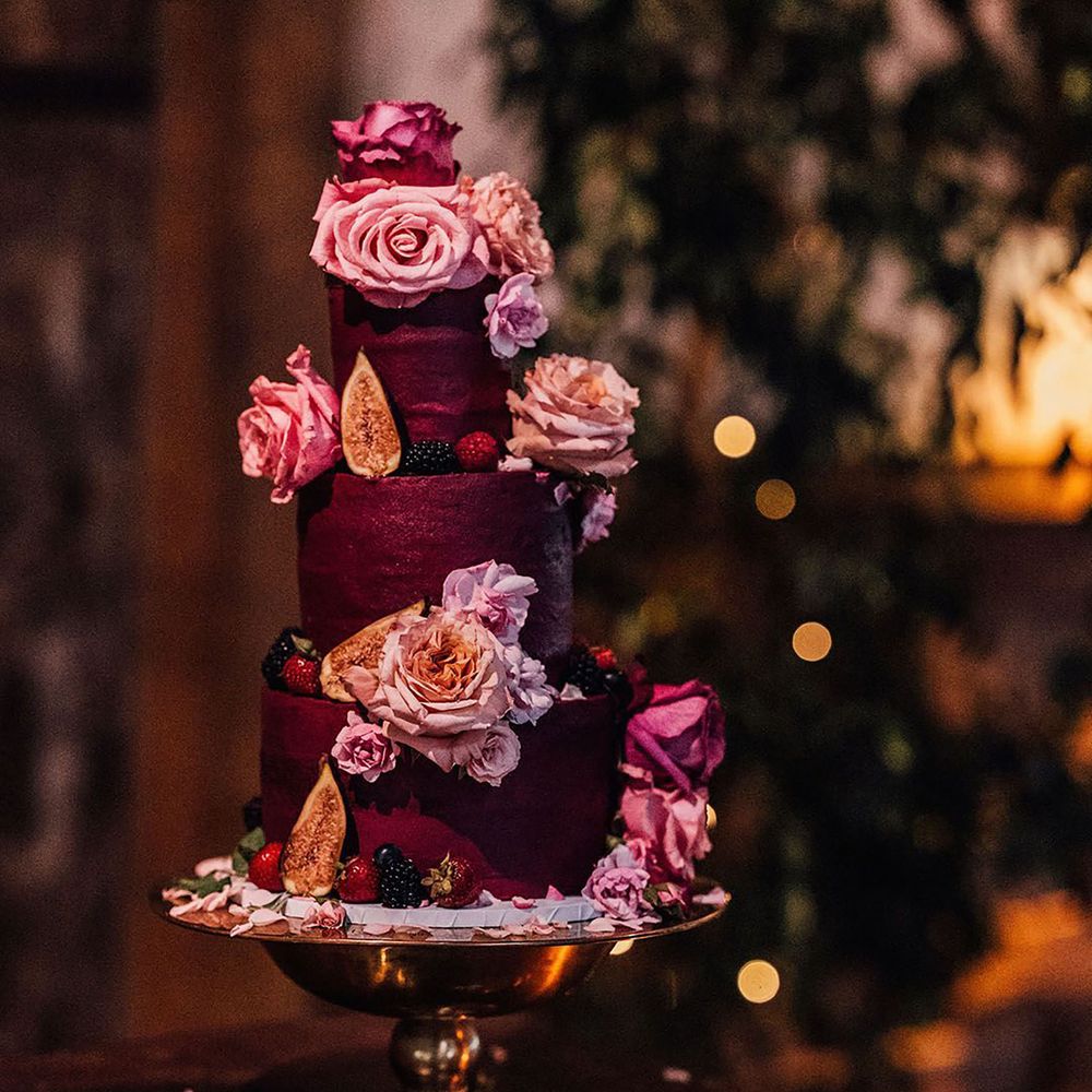 Dark red wedding cake with pink and purple flowers