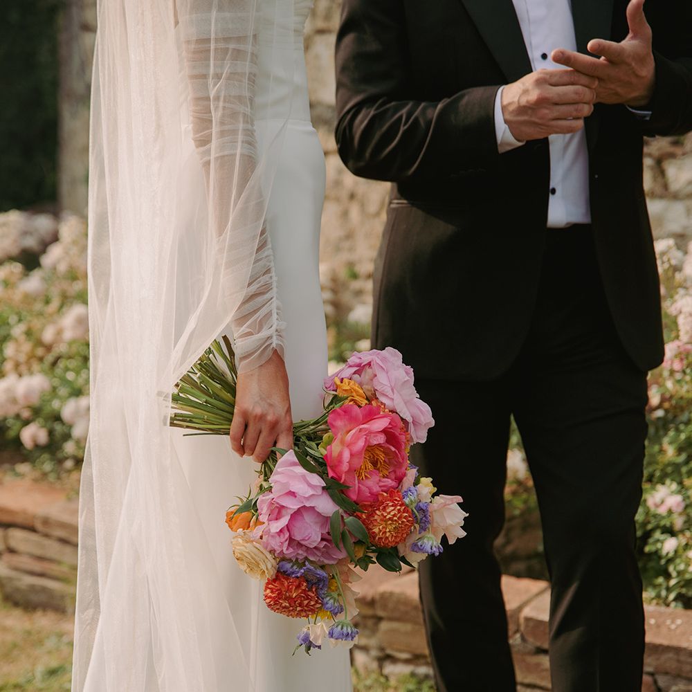 bride-carries-bright-colourful-pink-red-peony-wedding-bouquet