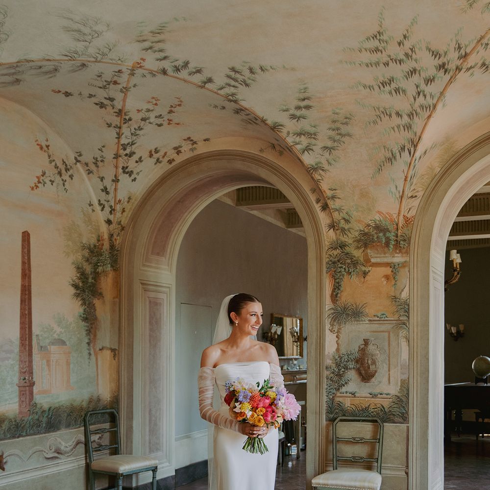 bride-wearing-strapless-dress-with-mesh-gloves-holding-colourful-bouquet