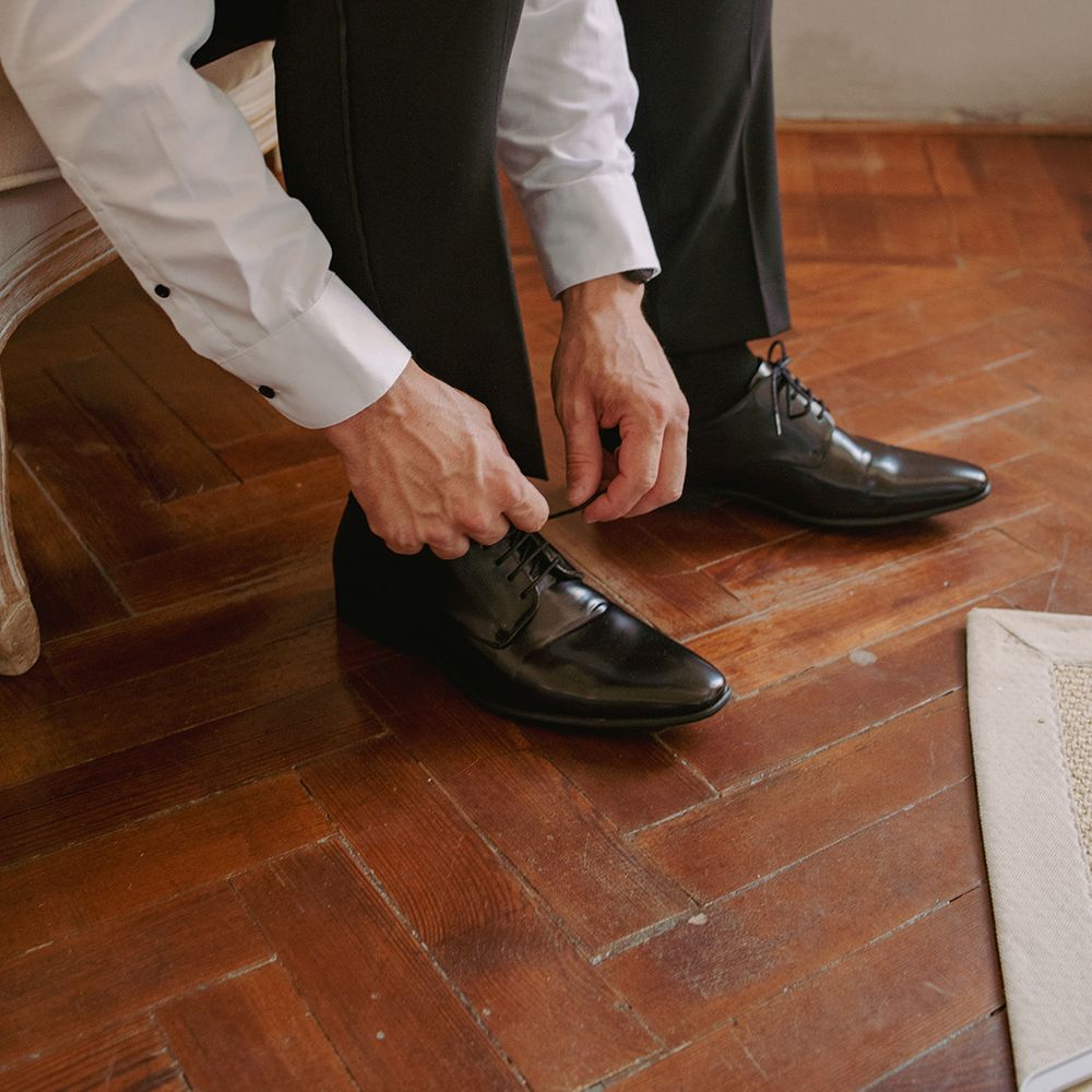 groom-getting-ready-putting-on-black-patent-shoes