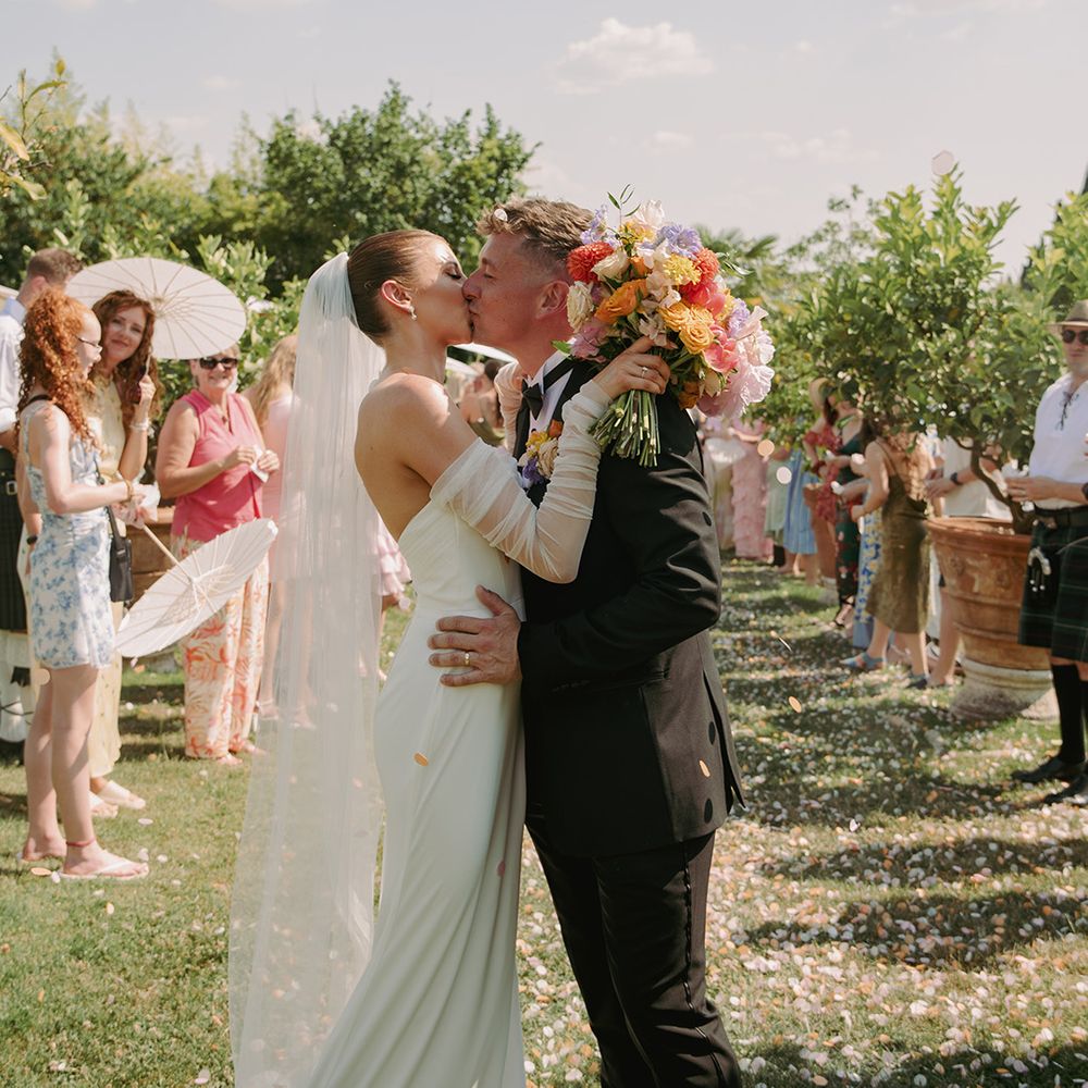 groom-kisses-bride-at-outdoor-wedding-ceremony