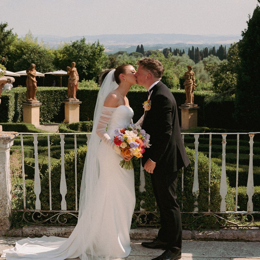 groom-kisses-bride-on-balcony-at-italian-villa
