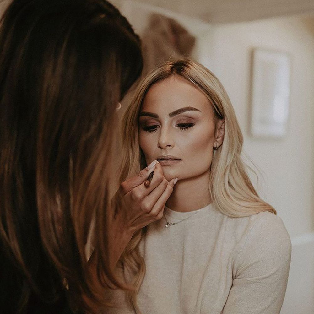 Bride with blonde hair gets her makeup done for her wedding day 