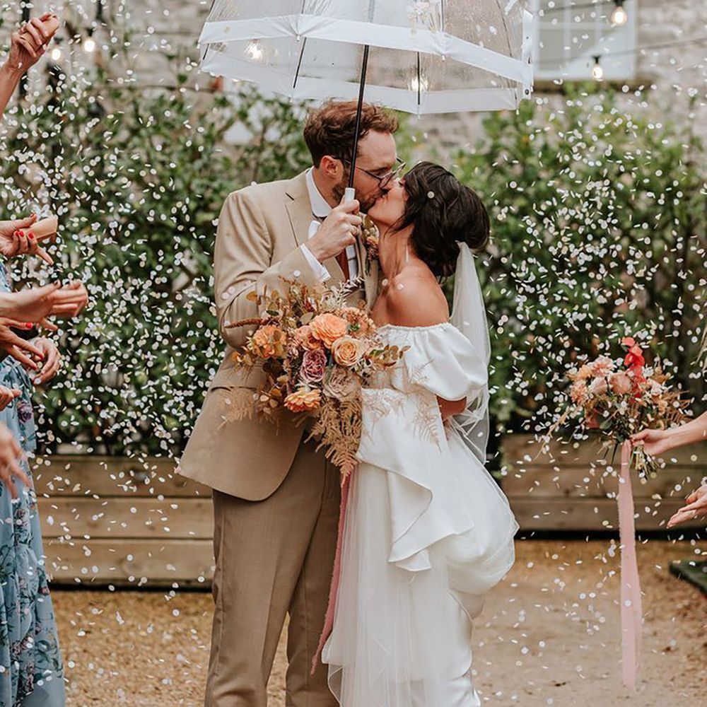 Couple has confetti moment under umbrella