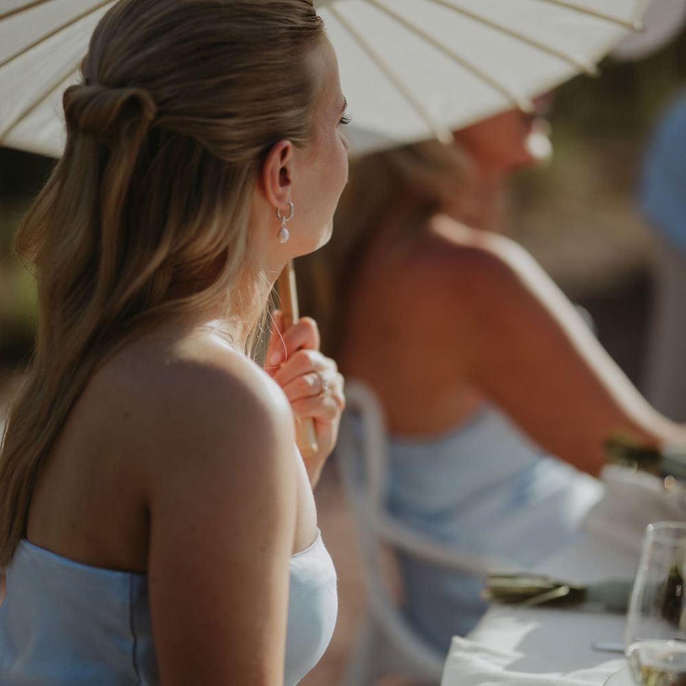 bridesmaid-holds-umbrella-in-blue-satin-bridesmaid-dress