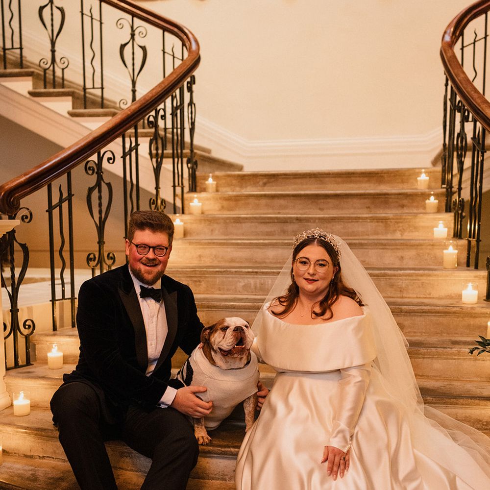 bride-and-groom-seated-on-staircase-with-pet-bulldog