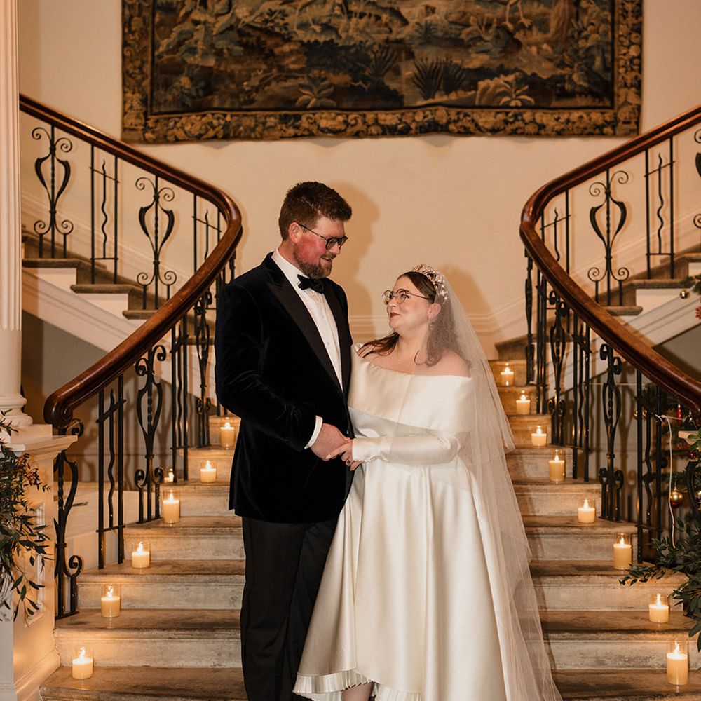 groom-in-black-tux-with-bride-in-off-the-shoulder-dress-at-festive-wedding