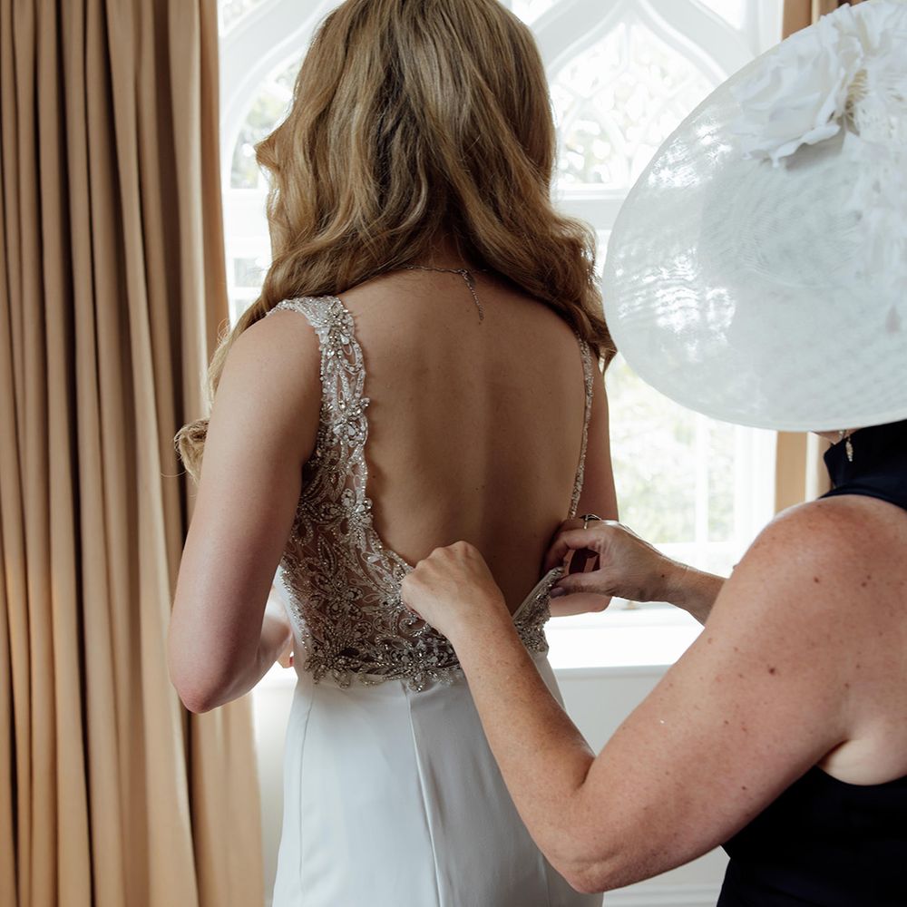 bride-gets-into-sparkly-open-back-wedding-dress