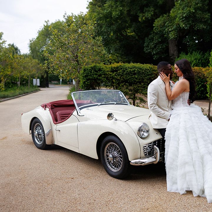 bride-and-groom-kiss-against-their-wedding-car