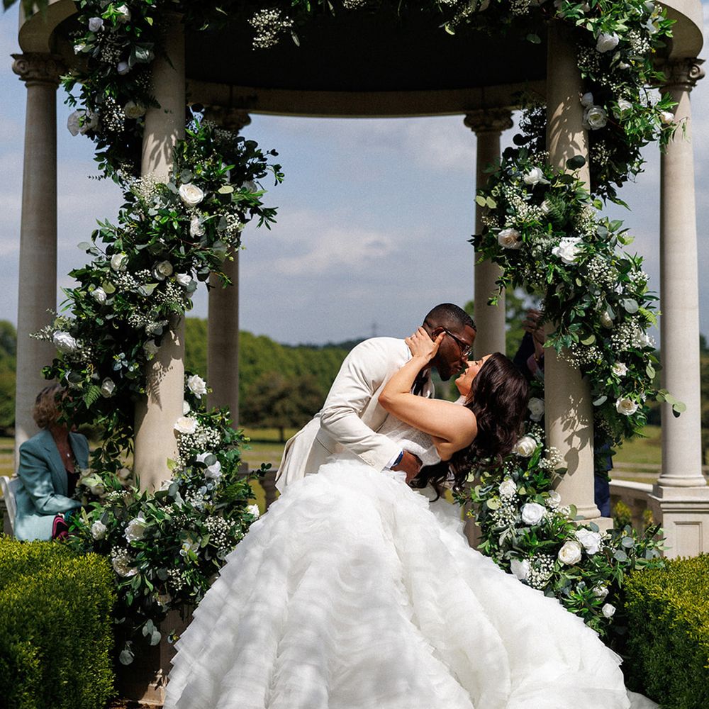 first-kiss-moment-for-couple-under-wedding-gazebo