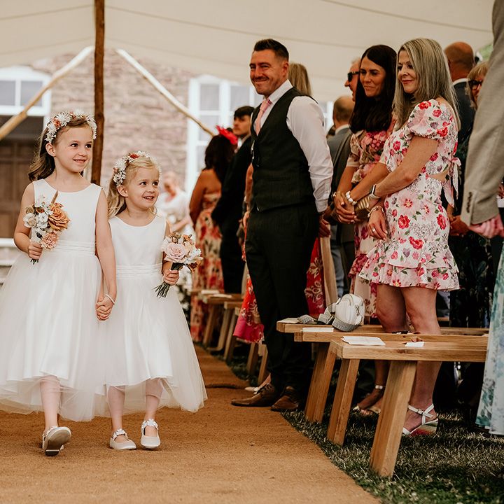 flower-girl-dresses-walking-down-the-aisle-at-marquee-wedding