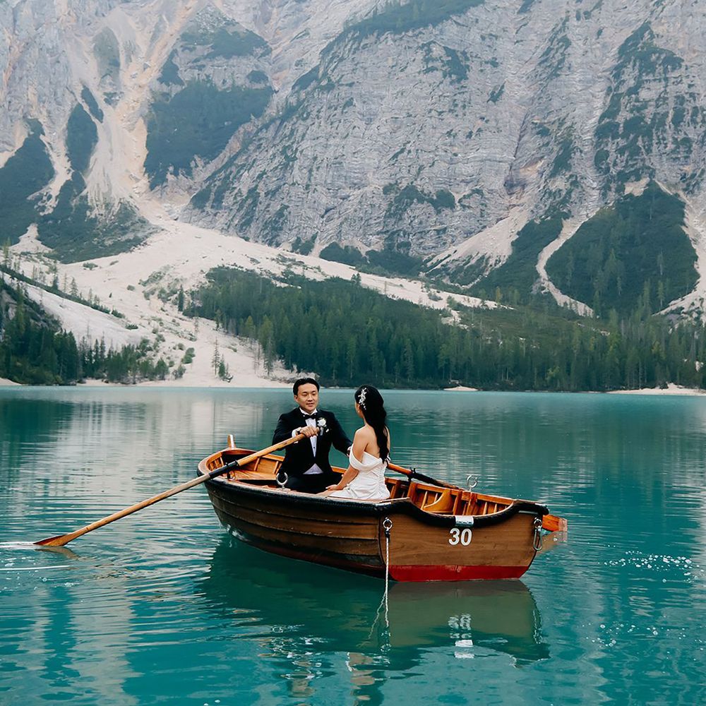 Couple rowing out on Dolomites lake on a small boat