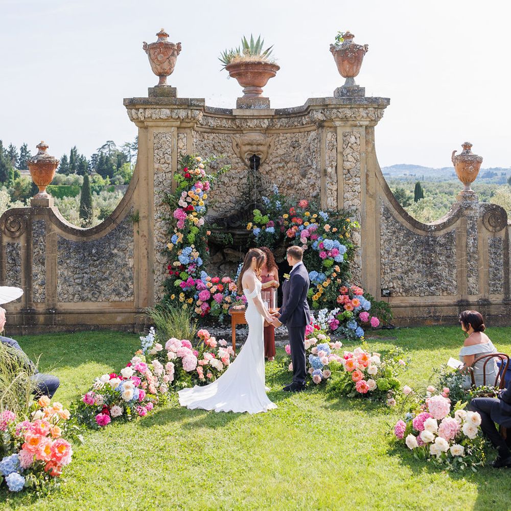 bright-colourful-wedding-flowers-at-wedding-with-couple-exchanging-wedding-vows