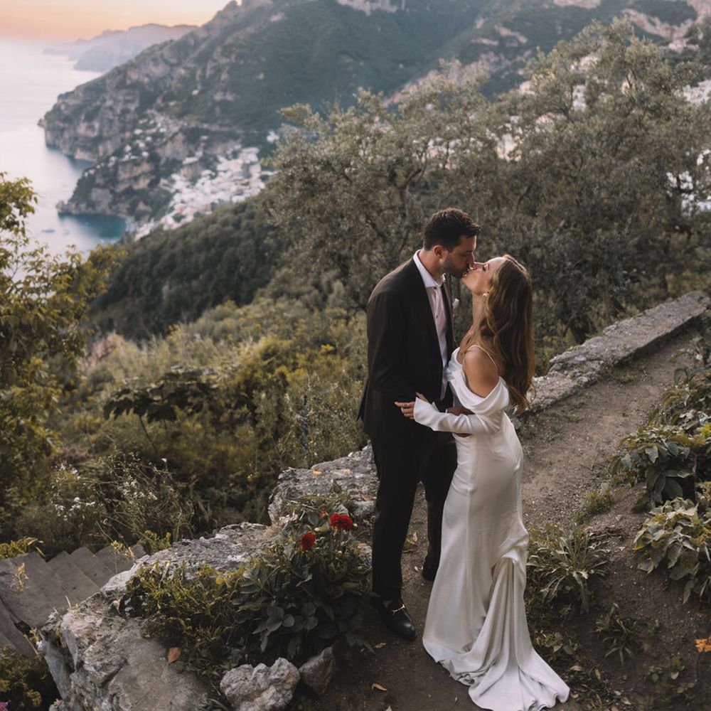 bride-and-groom-kiss-with-backdrop-of-positano