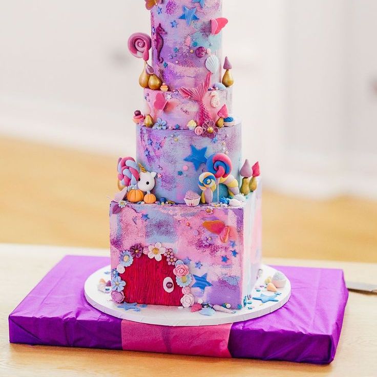 Four Tier Pink And Purple Iced Wedding Cake With Cartoon And Fairy Decorations