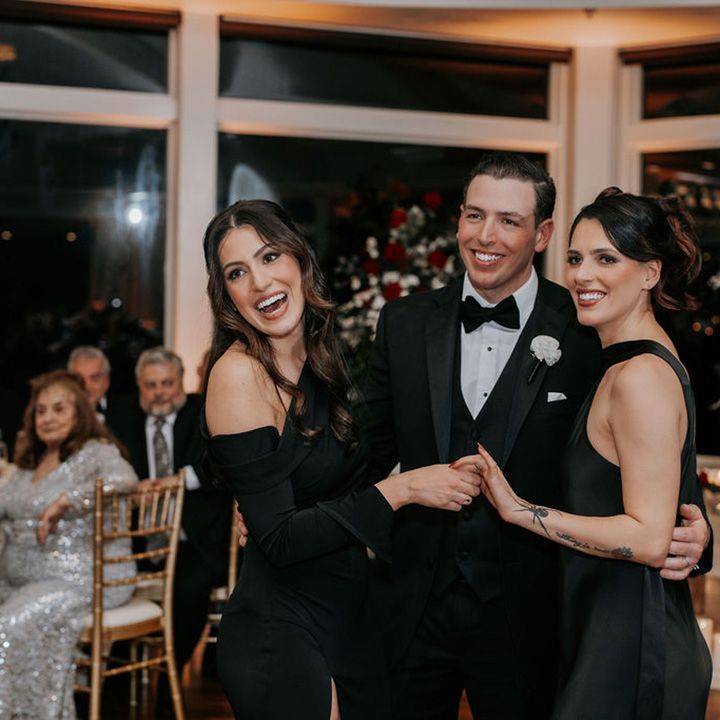 groom-dances-with-black-bridesmaid-dresses-sisters