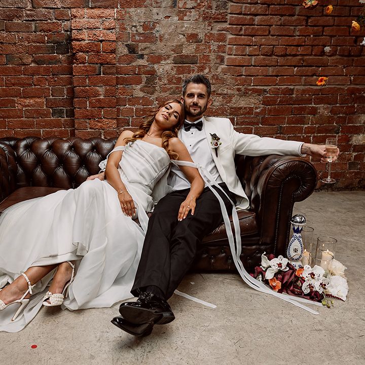 bride-and-groom-seated-on-brown-leather.
