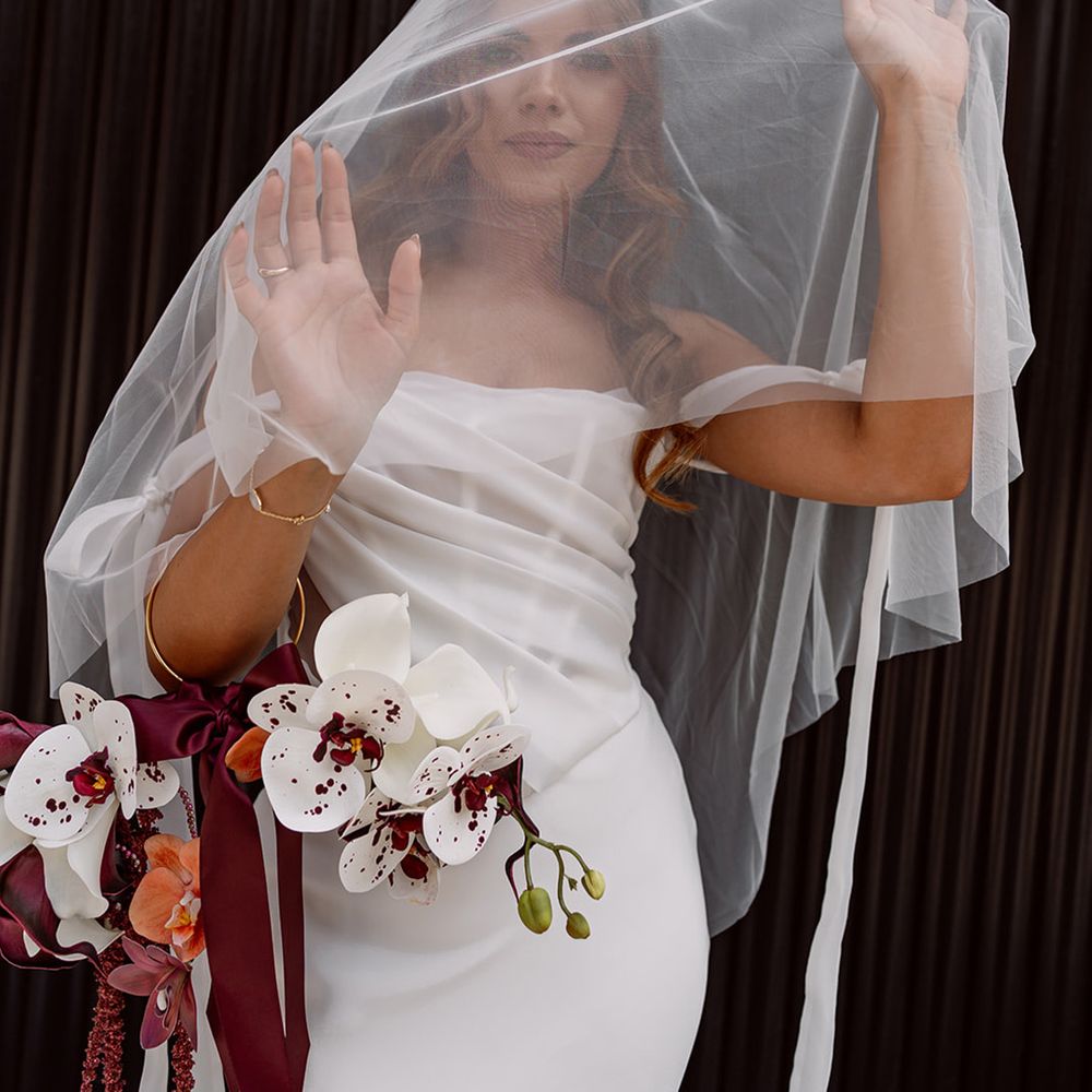 bride-wearing-drop-wedding-veil-and-pomander-bouquet