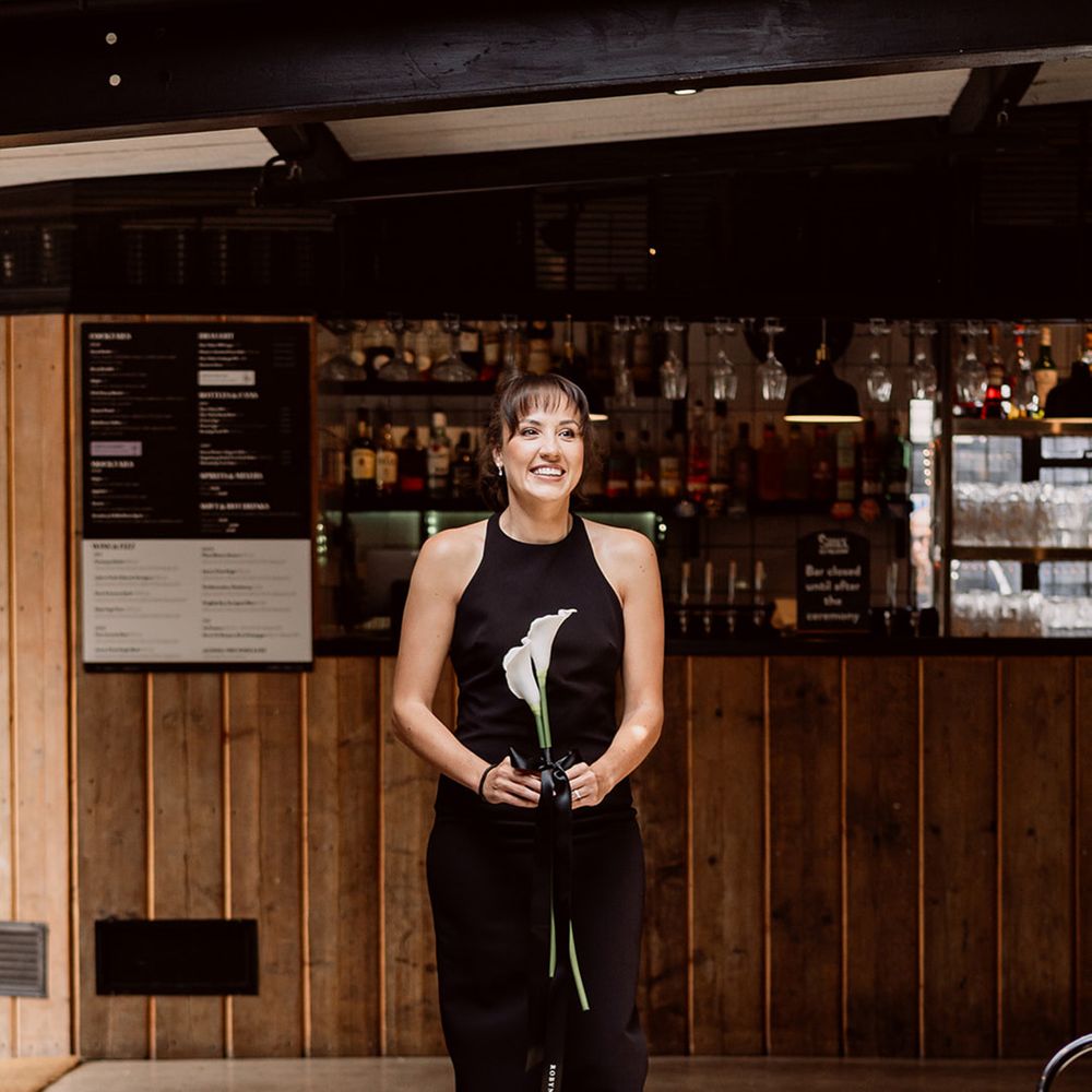 bridesmaid-wearing-black-bridesmaid-dress-with-white-lily-single-stem