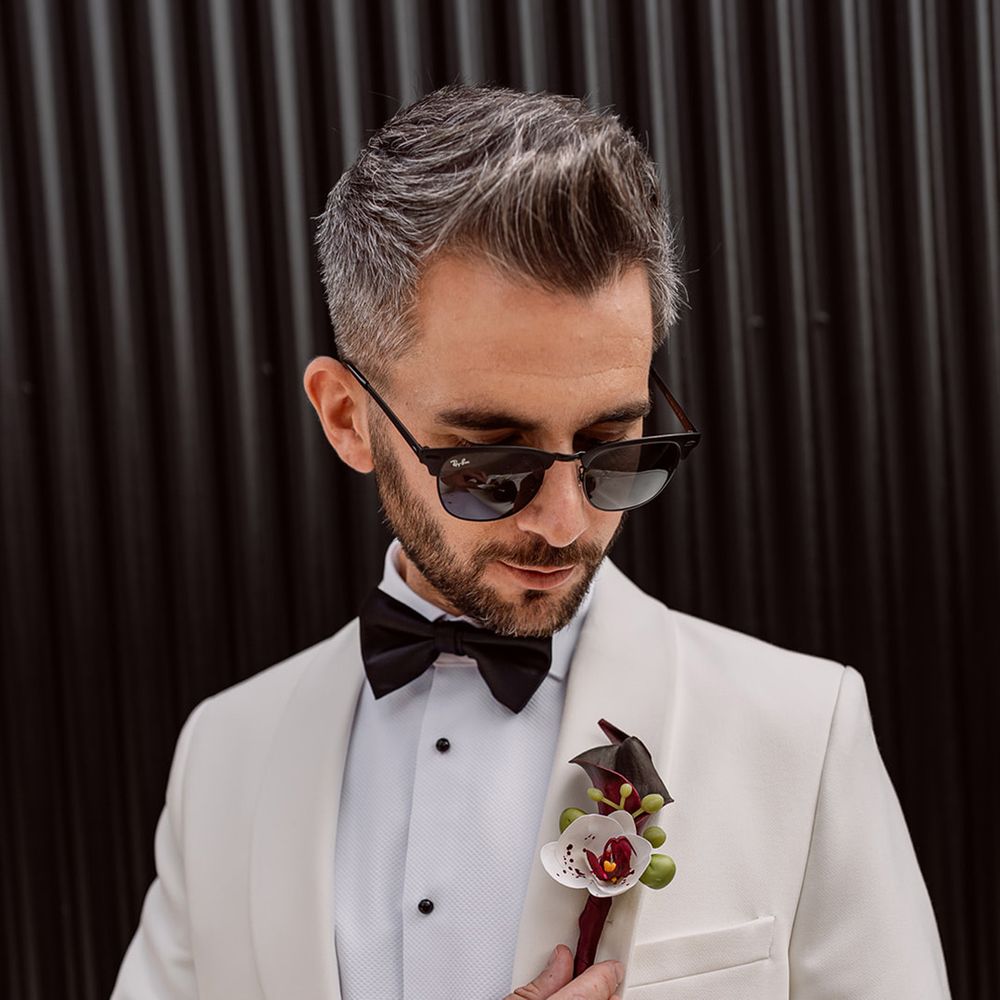 groom-in-white-suit-with-orchid-buttonhole