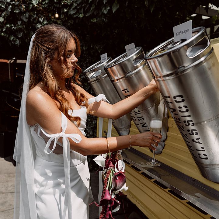 Bride pours drink from the wedding bar 