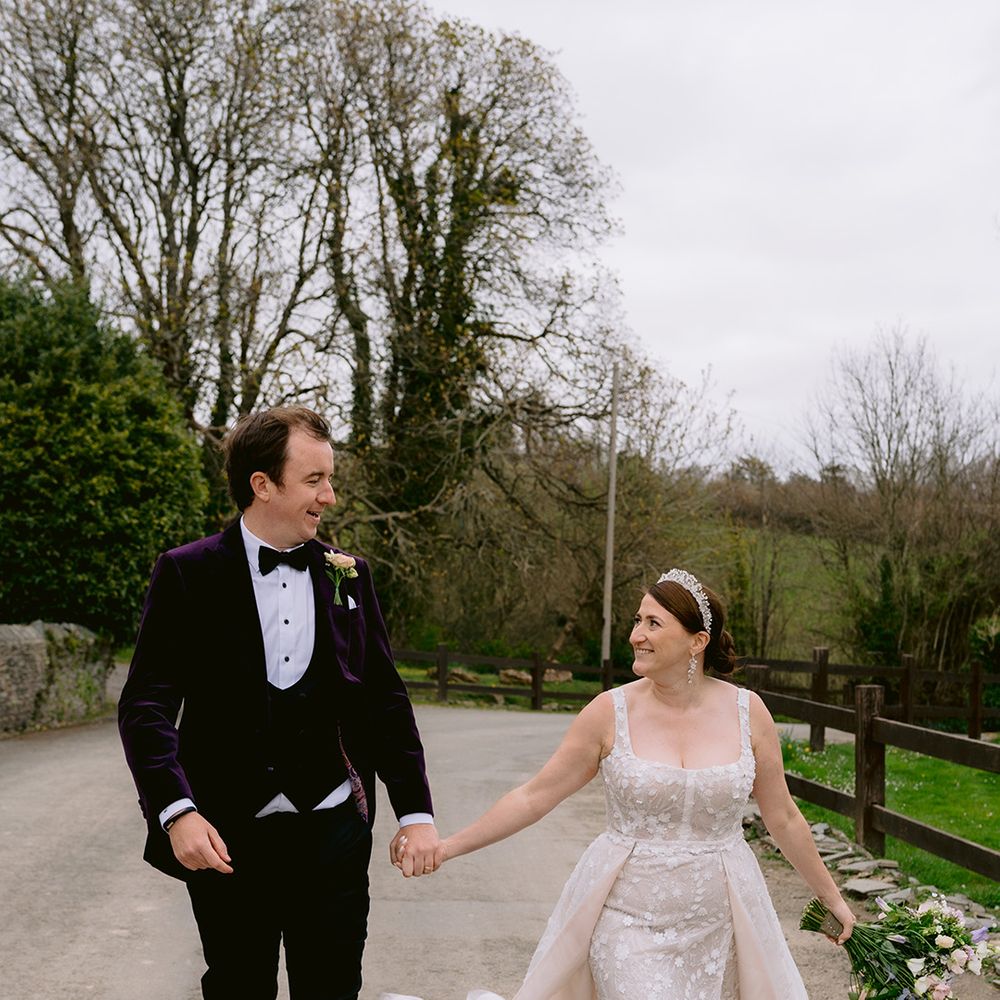 groom-in-purple-velvet-tux-walks-with-bride-in-sparkly-gown