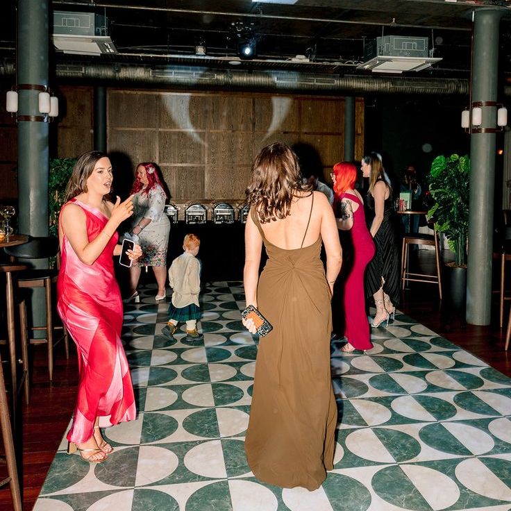 Guests at engagement party dancing under disco ball