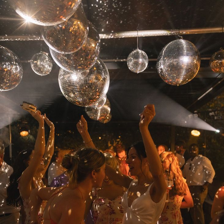 Disco Balls Hang Above Dance Floor At Wedding Reception