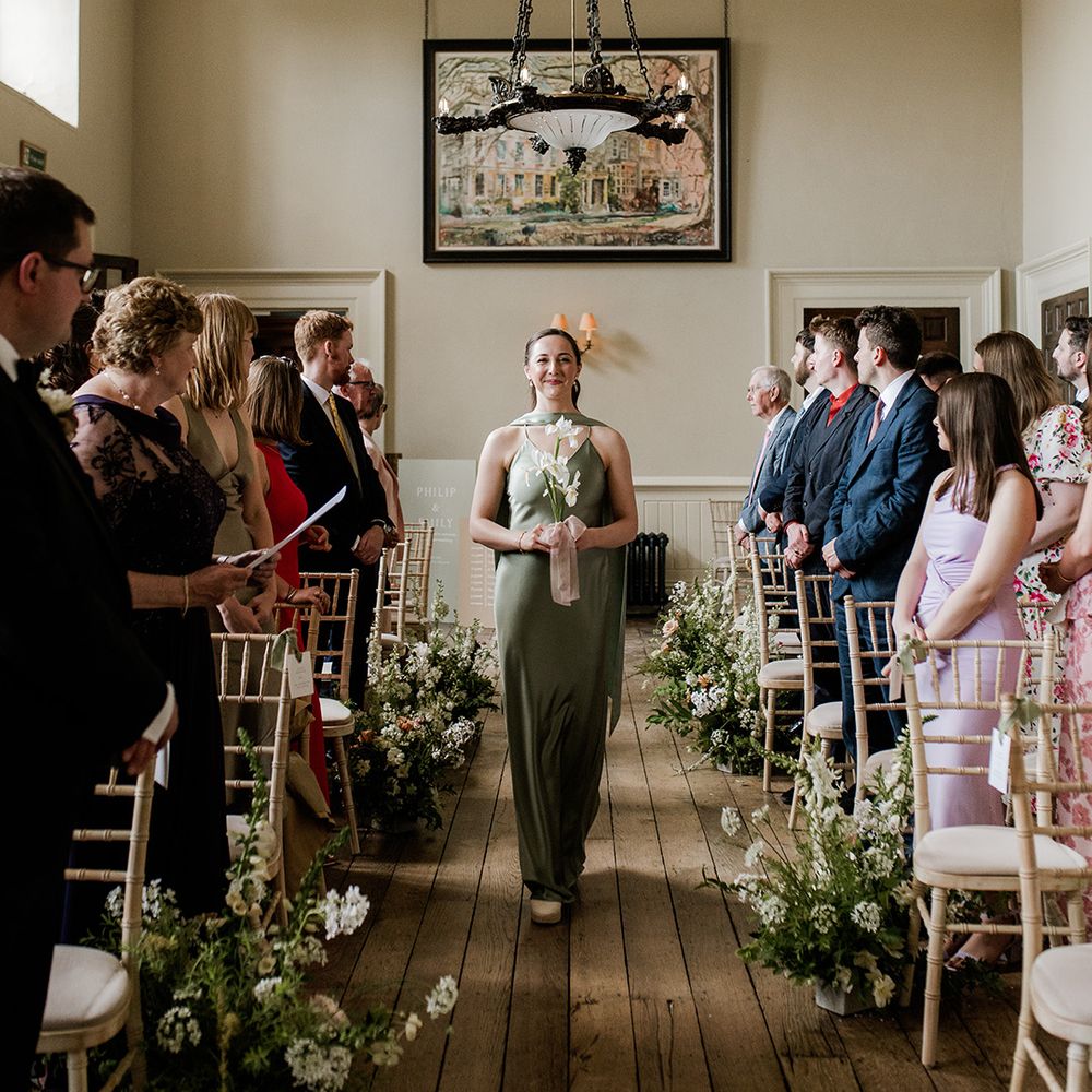 bridesmaid-walks-down-the-aisle-in-green-dress