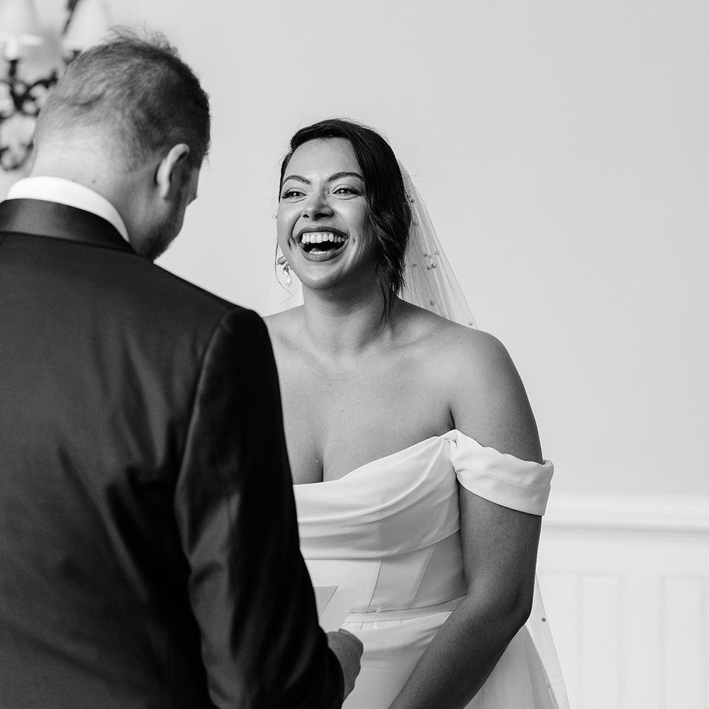 romantic-black-and-white-photo-as-bride-laughs-at-ceremony