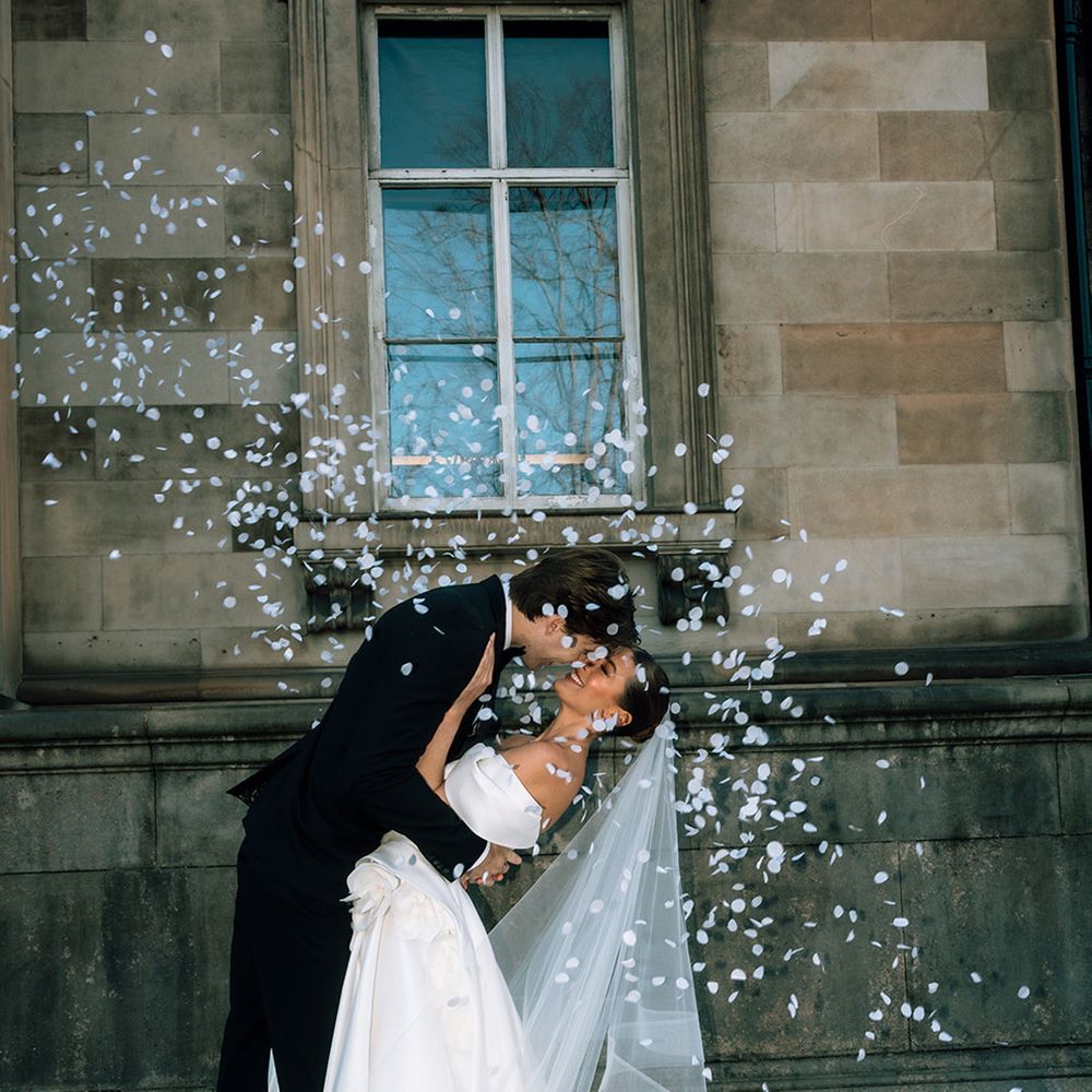 couple-kisses-as-white-confetti-flies-around-them