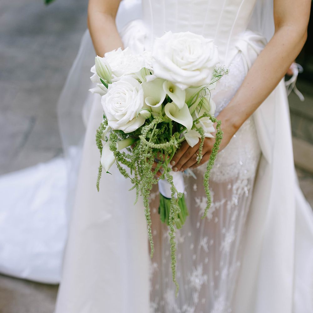 bride-in-corset-wedding-dress-carrying-white-bouquet-with-roses