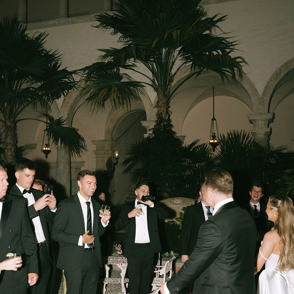groom-and-groomsmen-dancing-at-wedding-reception-wearing-black-tuxedo
