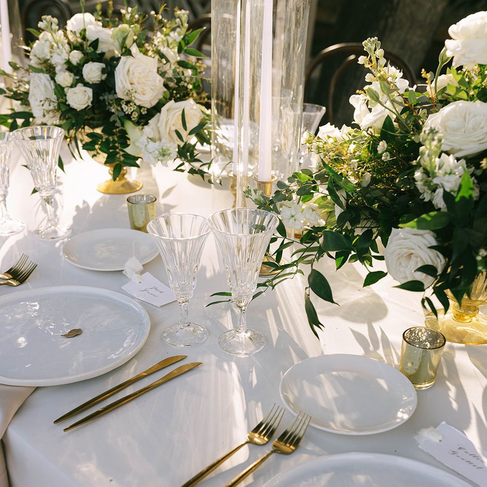 White wedding place setting with gold cutlery