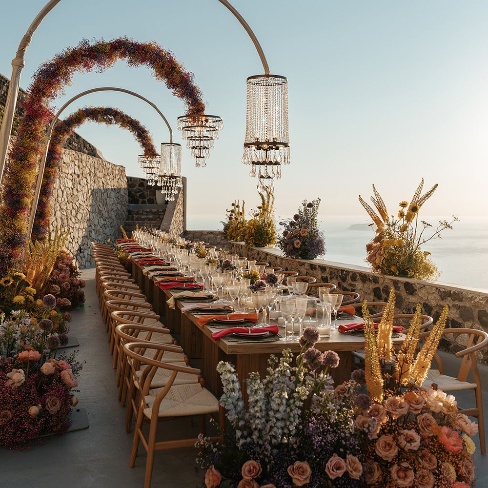 Colourful wedding flowers at outdoor wedding with chandeliers hanging over the tablescape