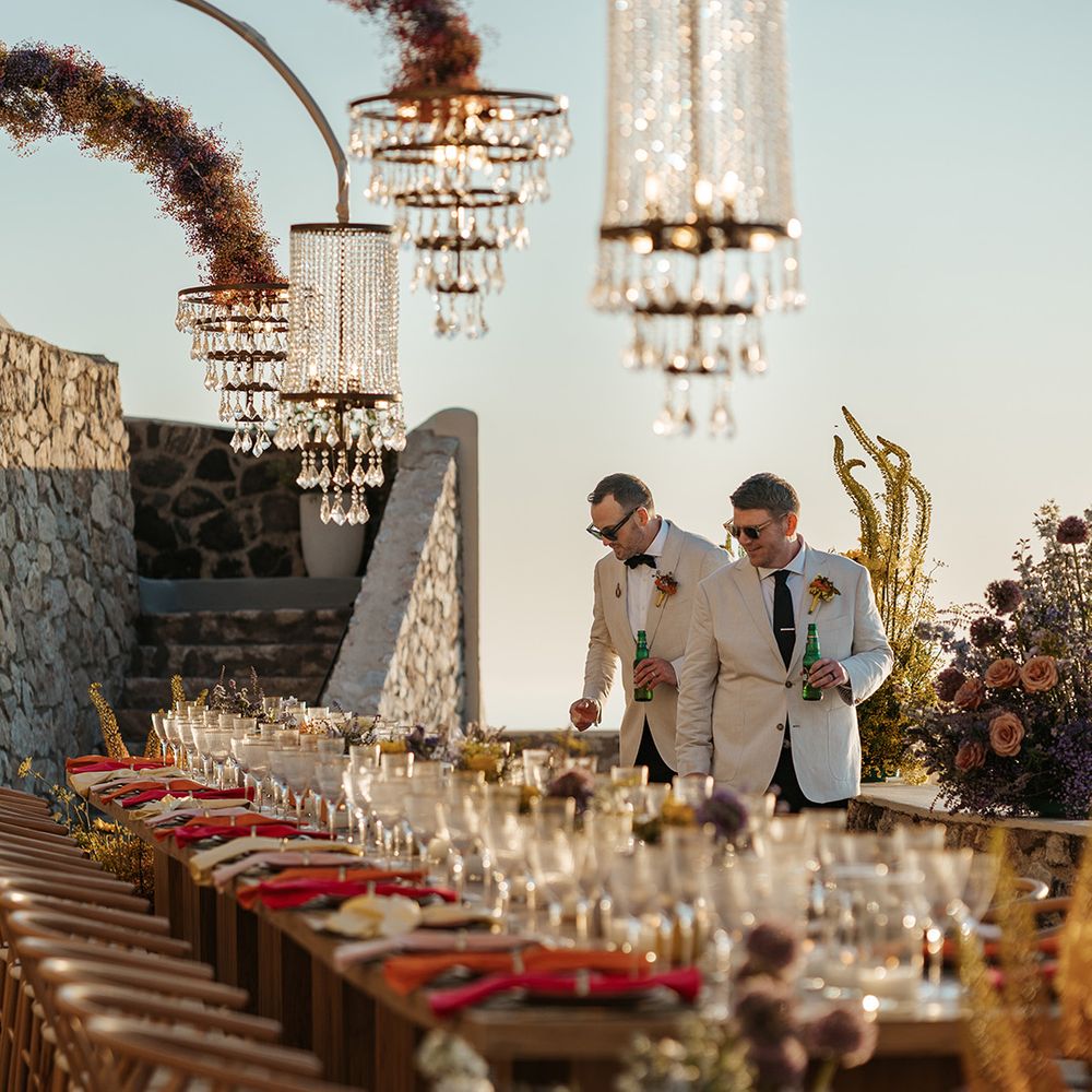grooms-react-to-seeing-stunning-wedding-tablescape-with-chandeliers-at-greece-wedding