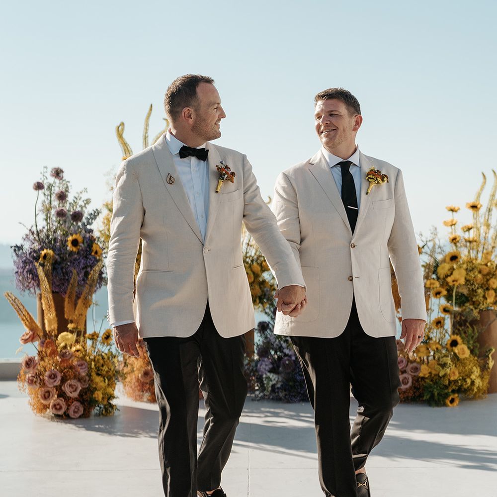 grooms-walking-holding-hands-in-matcing-wedding-suits