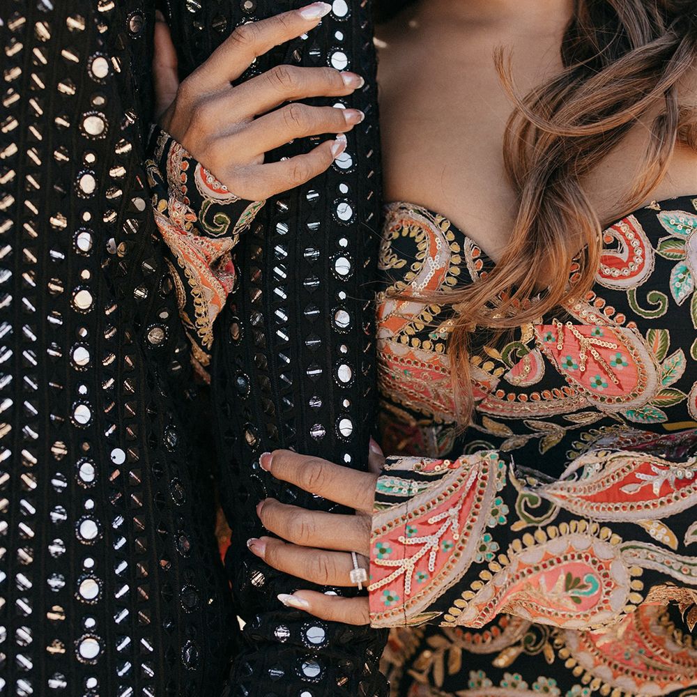 bride-in-floral-patterned-dress-holding-onto-grooms-arm