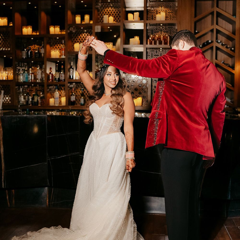 Bride in strapless Galia Lahav wedding dress with groom in red velvet tuxedo