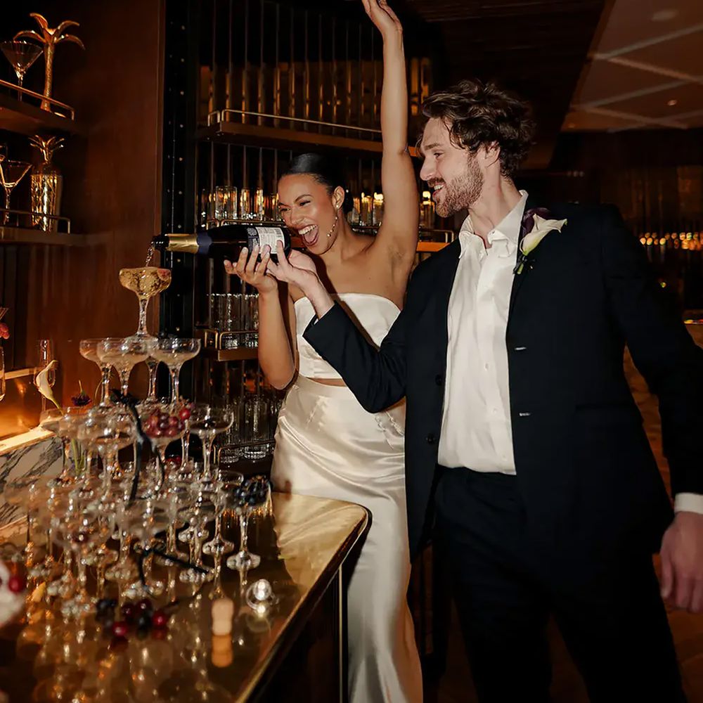 Couple pouring champagne tower at The Marylebone Hotel for engagement party