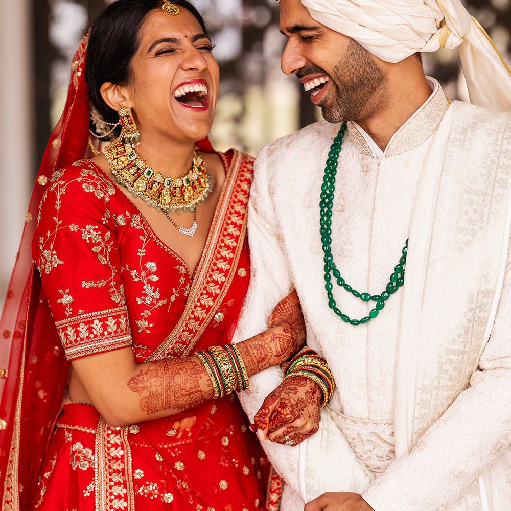 bride-in-red-and-gold-lehenga-with-groom-in-sherwani