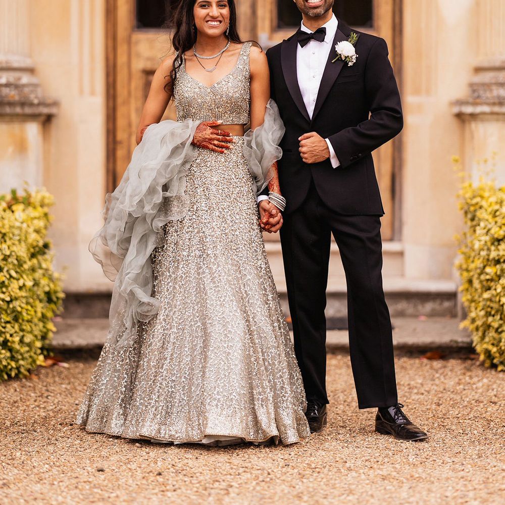 bride-in-silver-sparkly-lehenga-with-groom-in-black-tuxedo