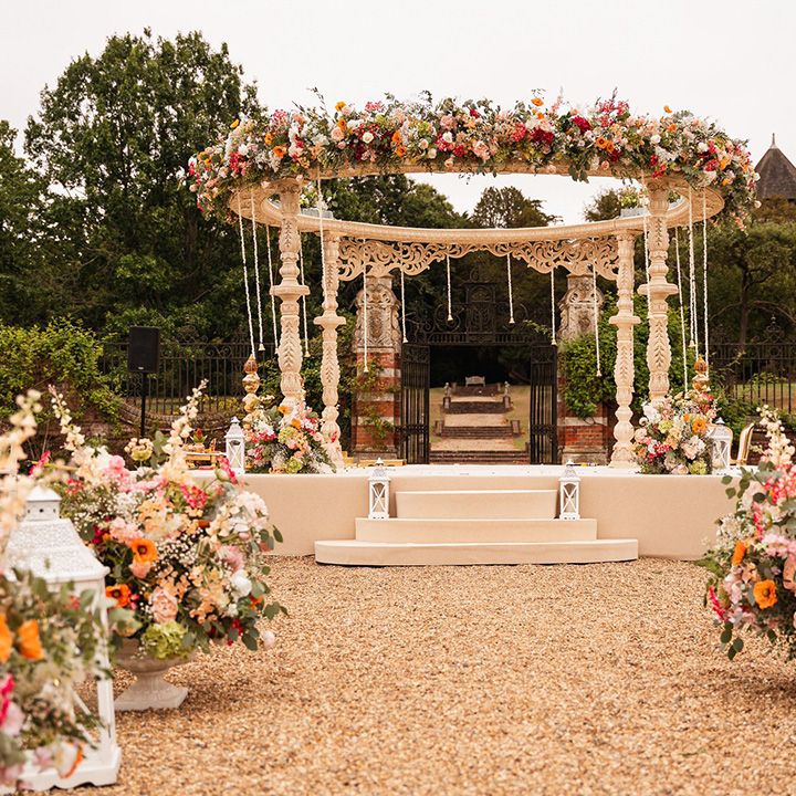 Mandap with deep orange and pink wedding flowers