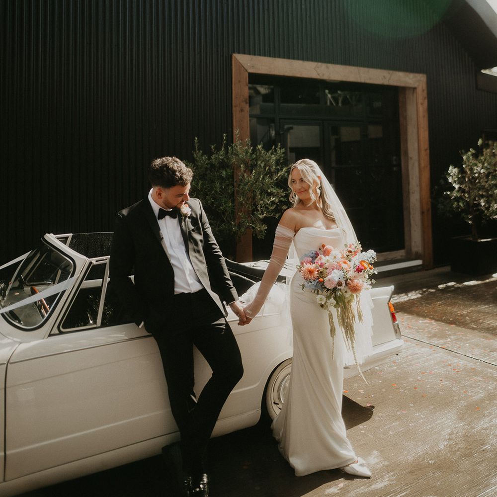 bride-and-groom-with-their-vintage-wedding-car.