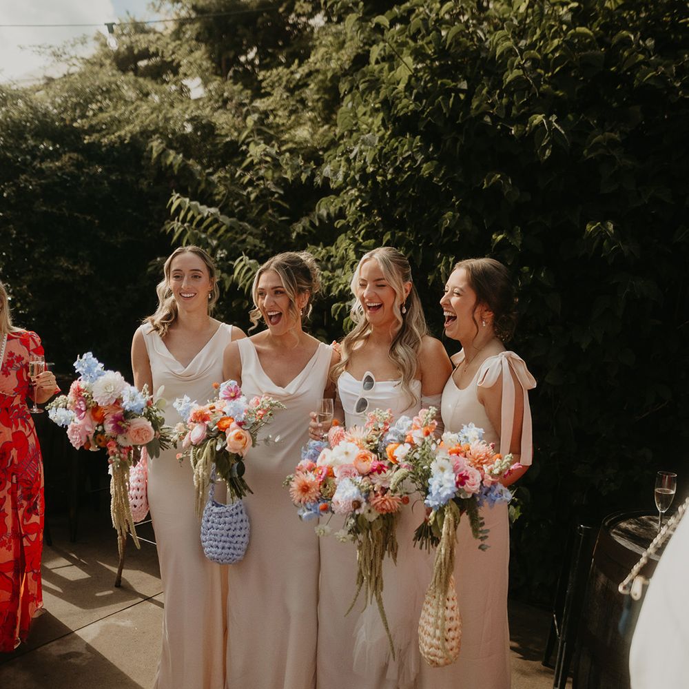 bridesmaids-in-cream-dresses-with-pastel-bags