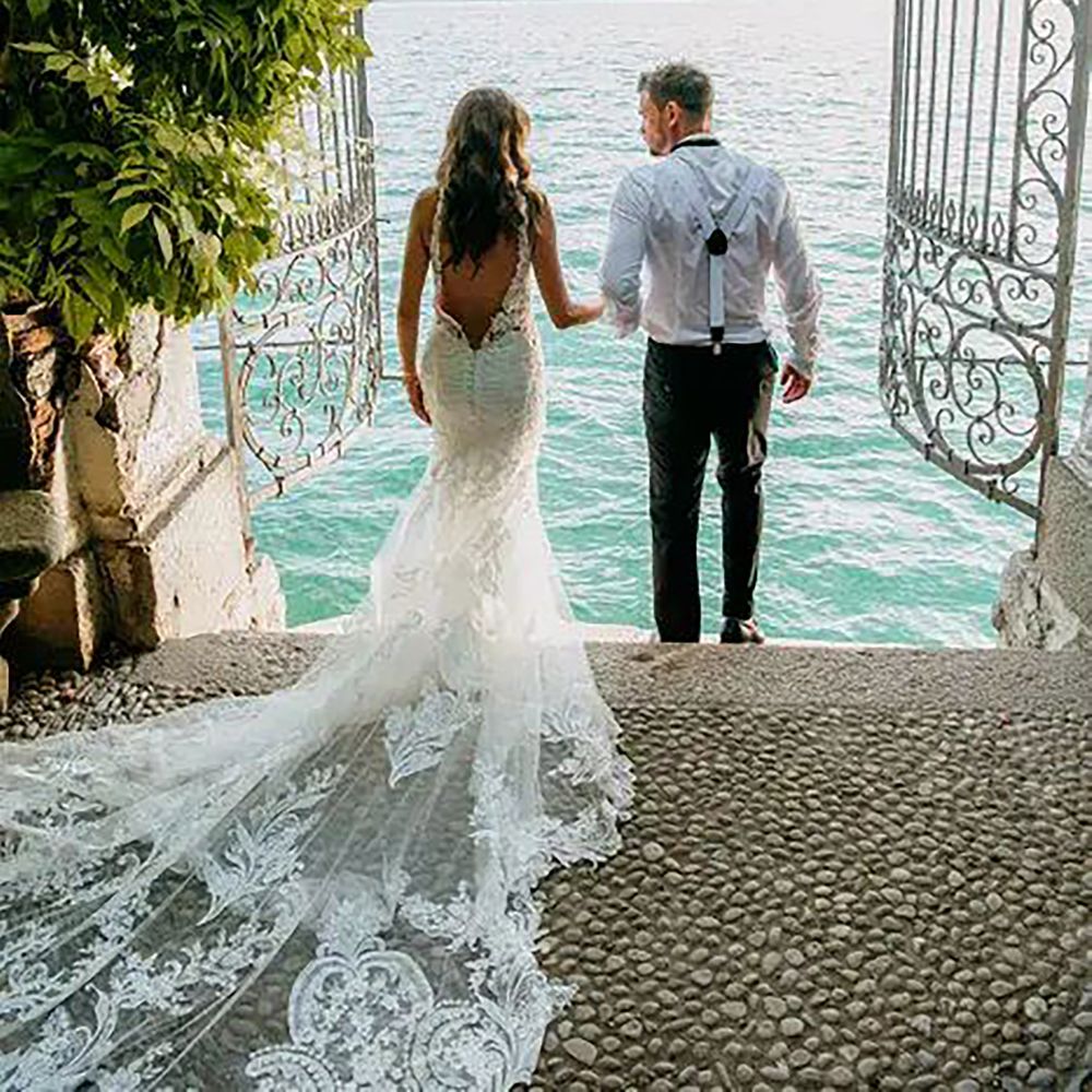 Bride and groom holding hands with view of water for destination wedding in Lake Como