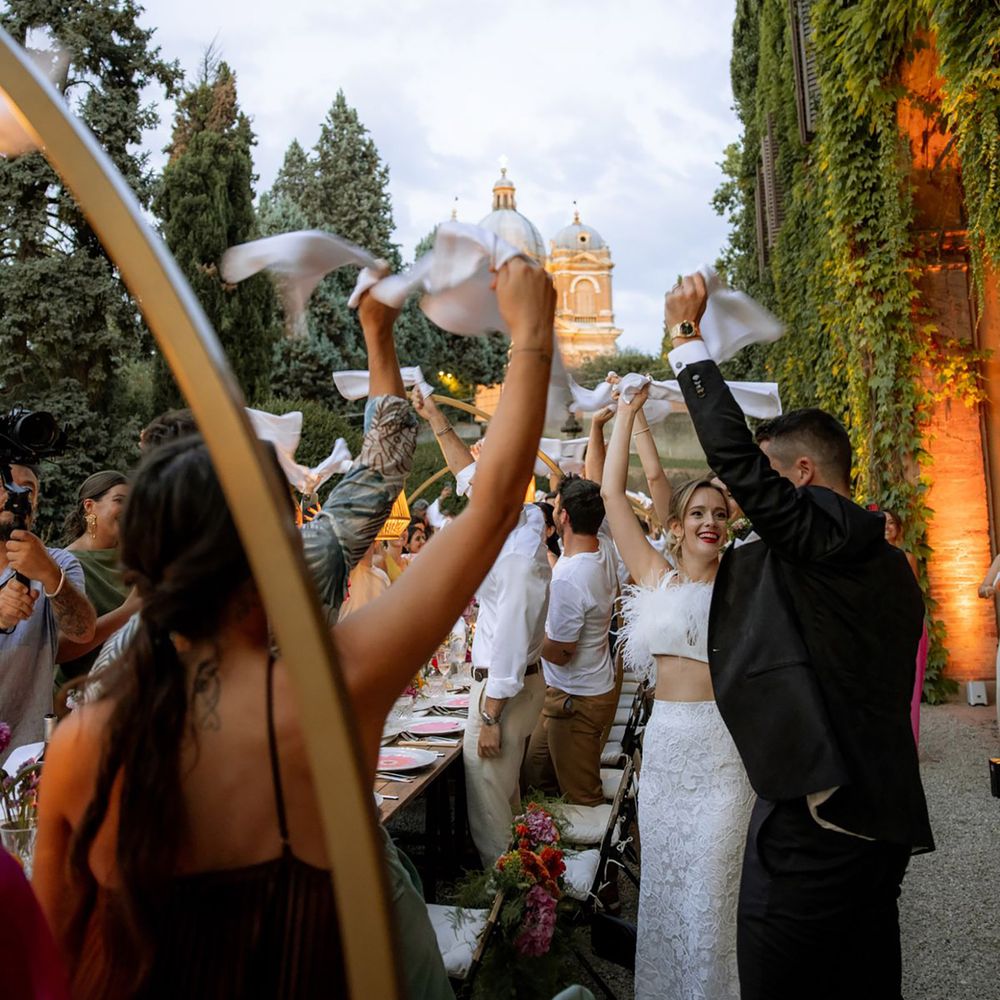 Guests waving napkins for outdoor destination wedding in Italy