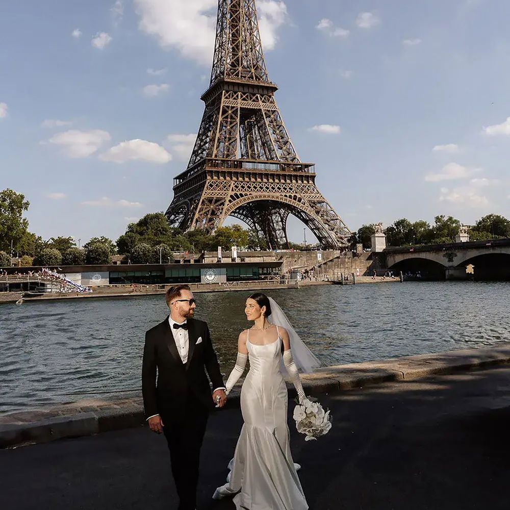 Bride and groom by Eiffel Tower for destination wedding in Paris